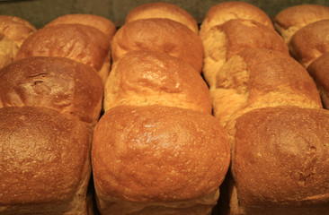 Heap of fluffy fresh baked bread loaves, closed up for background and texture
