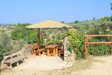 Wooden alcove with table and benches in summer. A place to rest in the heat in the mountains of the...