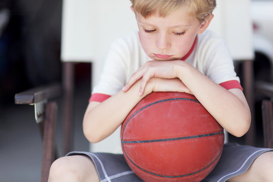 A Sad Little Boy With A  Basketball