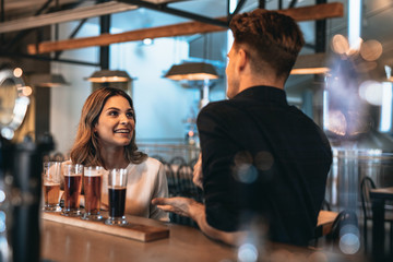 Young couple at bar with different craft beers