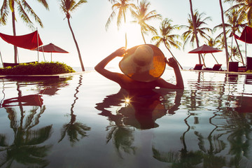 Woman With Hat Standing Alone in Swimming Pool