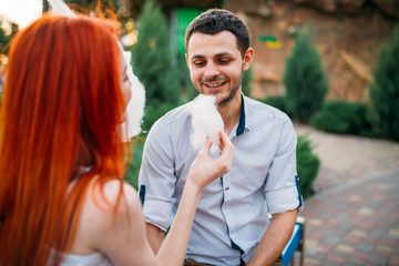 Fototapeta premium Woman feeding man cotton candy, romantic date