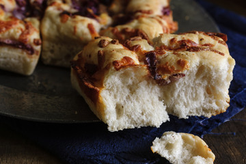 Focaccia bread topped with caramelised red onion and mozarella cheese shot with low key lighting