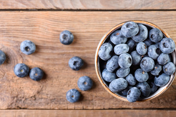 Fresh blueberry in a cup on an old wooden background top view. Fresh blueberries. Blueberry. Blueberry closeup