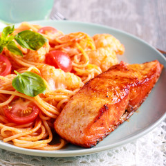 Fried trout fish and spaghetti on plate