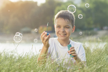Little boy blows soap bubbles