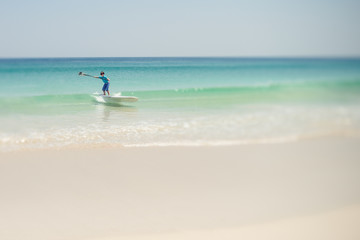 Boy on a stand up paddle board at the beach