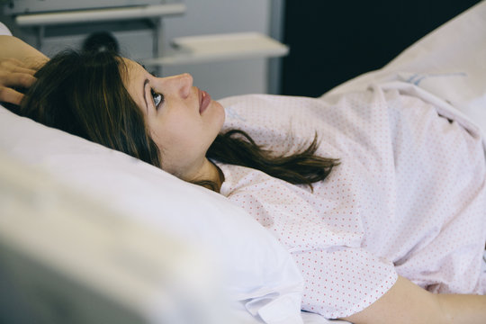 Young woman lying on hospital bed