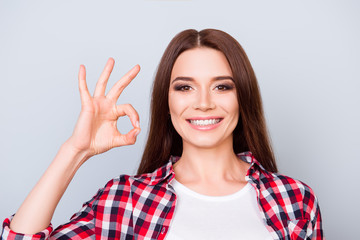 Cheerful young brunette pretty girl on the pure blue background is smiling, wearing casual...