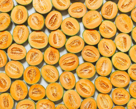 group of cantaloupe halves brightly lit