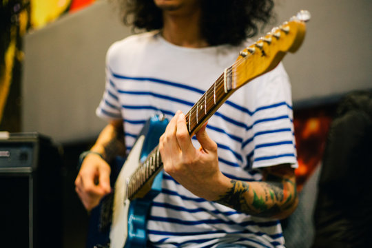 Man playing an electric guitar in a studio