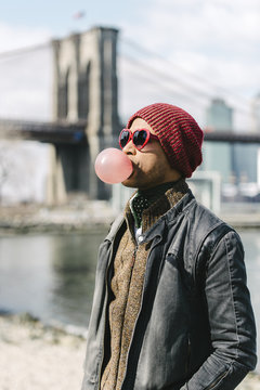 Blowing bubble gum, heart shaped glasses portrait in New York City
