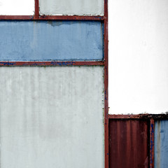 Geometric iron texture steel door background. Red, blue and grey metal sheet gate. Composition and elements of visual design. Vintage and hipster. De stijl. Close up.