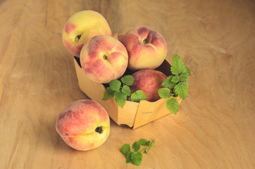 Ripe sweet peaches in wicker basket