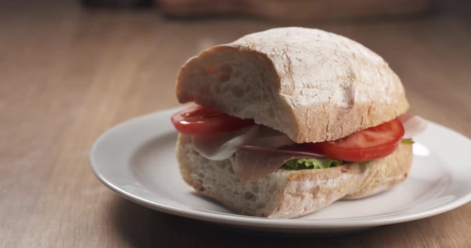 Slide shot of ciabatta sandwich with speck, mazzarella and vegetables