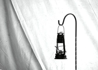 Black and white, old, civil war times gas lantern hanging at the entrance of a civil war reenactment Shelter Tent in Duncans Mills, California, USA