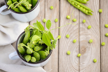 Fresh green peas on rustic wooden background