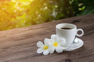 Relaxing time with a cup of coffee in a garden with warm sunlight