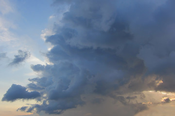 Fototapeta na wymiar Big high cumulus cloud on the blue sky on sunset or sunrise
