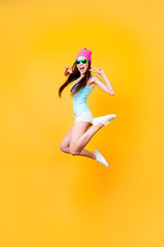 Wow! Happiness, dream, fun, joy concept. Very excited happy cute asian teen is jumping up, wearing casual summer clothes, white shoes, on bright yellow background