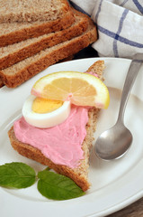 Toast avec du tarama, une rondelle de citron, une rondelle d’œuf dur et des feuilles de menthe