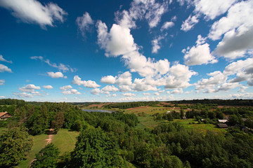 Fototapeta na wymiar Landscape with forest, lake and sky with clouds