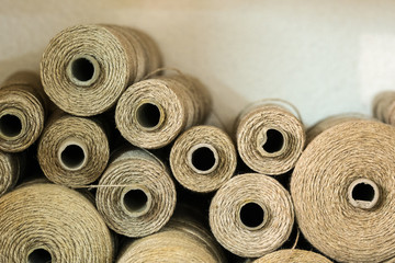 rolls and spools of brown thread on a shelf in a weaving studio