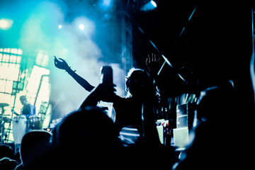 Obraz na płótnie Canvas crowd with raised hands at concert - summer music festival