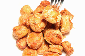 fork with deep fried meat rolls on white paper closeup shot