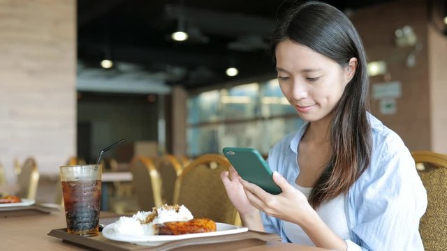 Woman working on mobile phone in restaurant