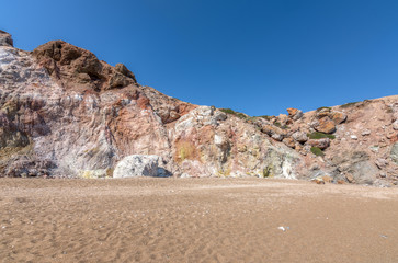 Fototapeta na wymiar Colourful volcanic rock formations in Paliochori beach of Milos, Greece