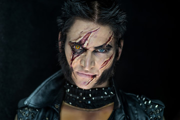 Professional make-up werewolf Wolverine with scars and orange eye