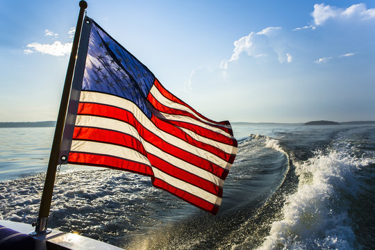 American flag on boat moving in bay