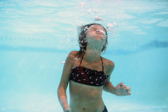 A Girl Holding Her Breath While Swimming Underwater