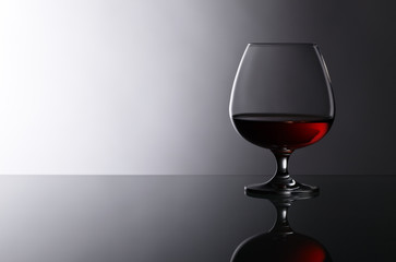 snifter of brandy on glass table