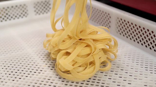 Automated food factory make fresh pasta, chef in modern restaurant prepare pasta, spaghetti tagliatelle