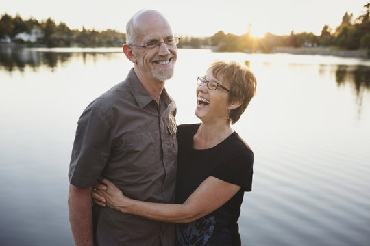 Retired couple laughing together near lake