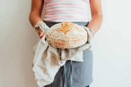 Woman holding a loaf of sourdough bread