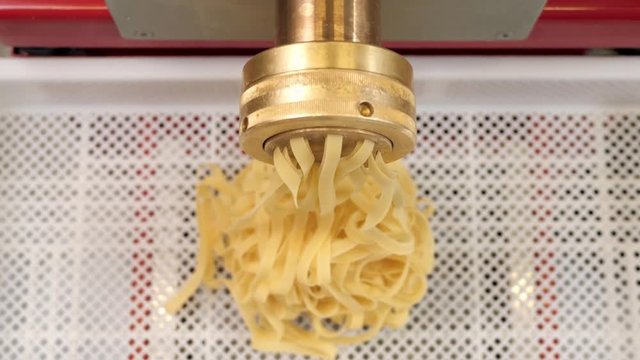 Automated food factory make fresh pasta, chef in modern restaurant prepare pasta, spaghetti tagliatelle