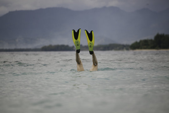 Diving under water with flippers on.
