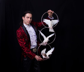 The magician with a two flying white Doves