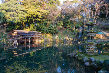 Fototapeta na wymiar Japanischer Garten Haus am See Wasser Spiegelung Wasserfall