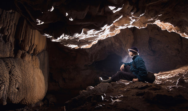 Man in underground cave with limestone formations