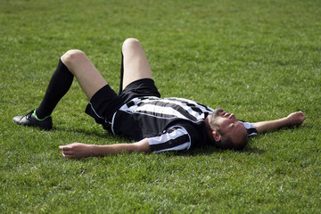 Fototapeta premium soccer player lying down on grass