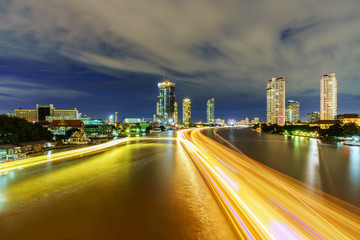 Beautiful cityscape of Bangkok viewing traffic on Chao Phraya river in twilight from Taksin Bridge , Thailand
