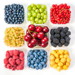 Collage of different fruits and berries isolated on white. Blueberries, cherries, blackberries, grapes, strawberries, currants. Collection of fruits and berries in a bowl. Top view