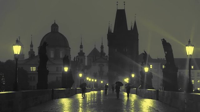 Pedestrians with Umbrellas on the Charles Bridge at Night. Slow Motion