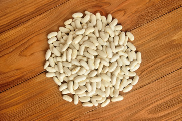 A small heap of beans on a wooden surface. Top view.