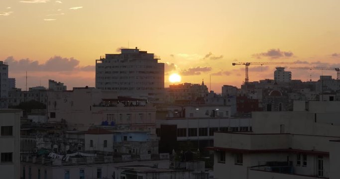 A medium establishing shot of the sun setting over Havana, Cuba.  	