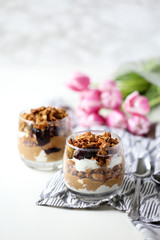 Breakfast Granola Parfait with Peanut Butter Strawberry Jelly and Greek Yogurt in Glass on Marble with Rose Tulips